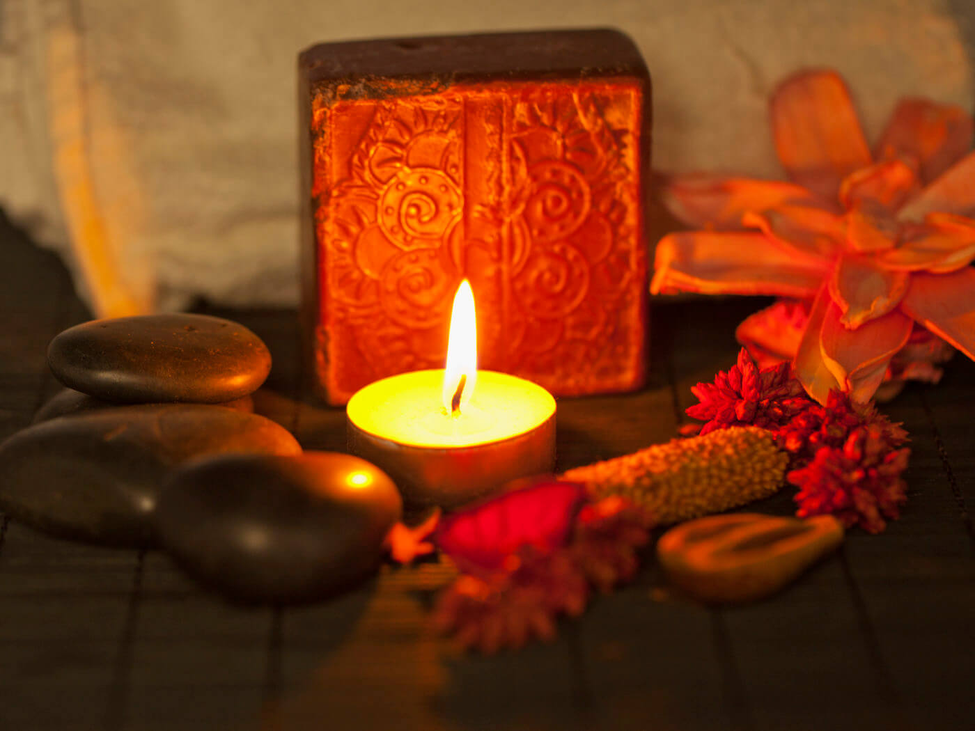 Brown soap, candle, stones and towel over wooden background