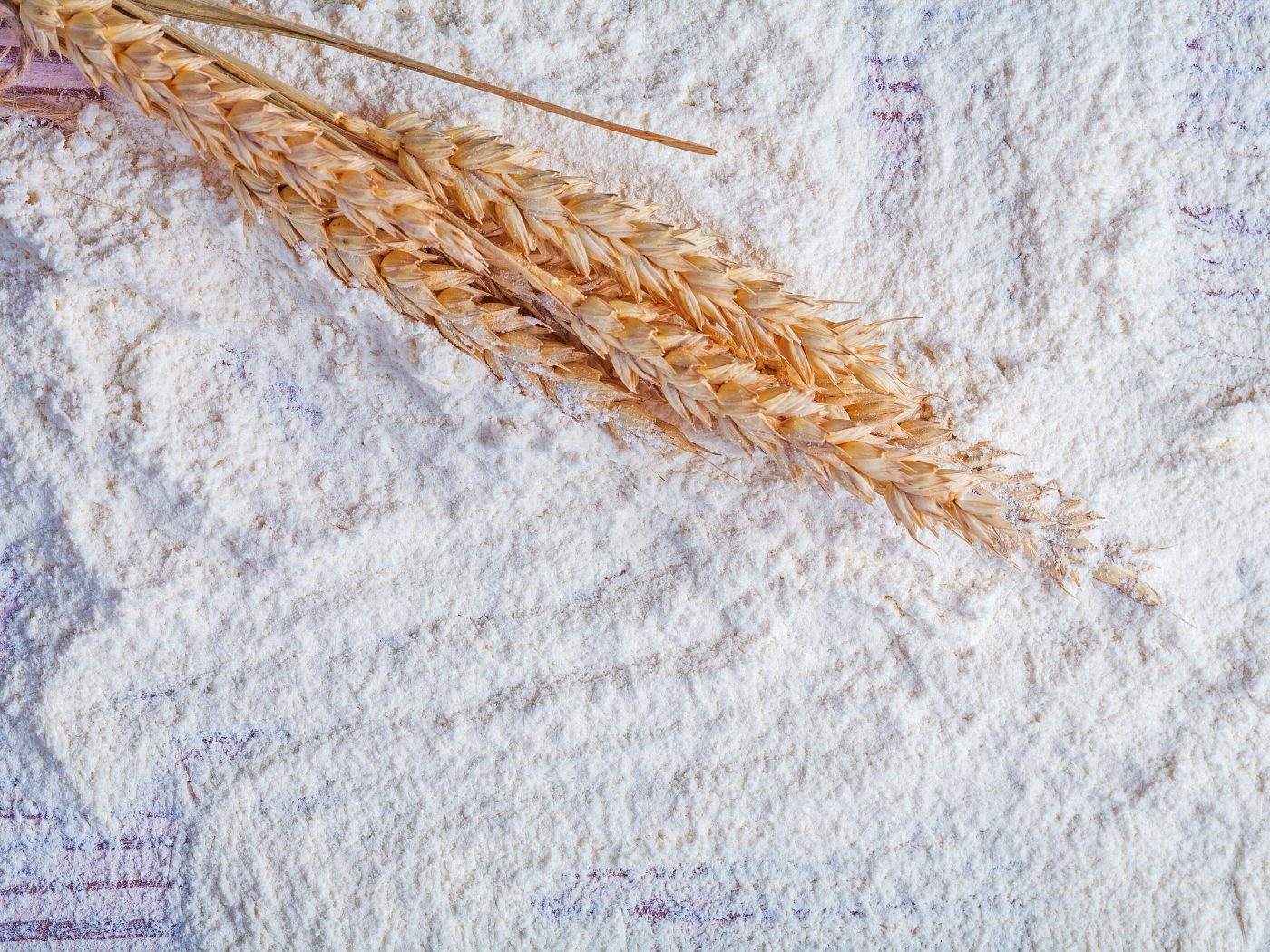 small bunch of wheat ears on flour food and drink concept