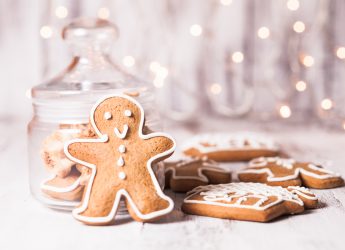 Gingerbread cookies on a table and Christmas lights on background