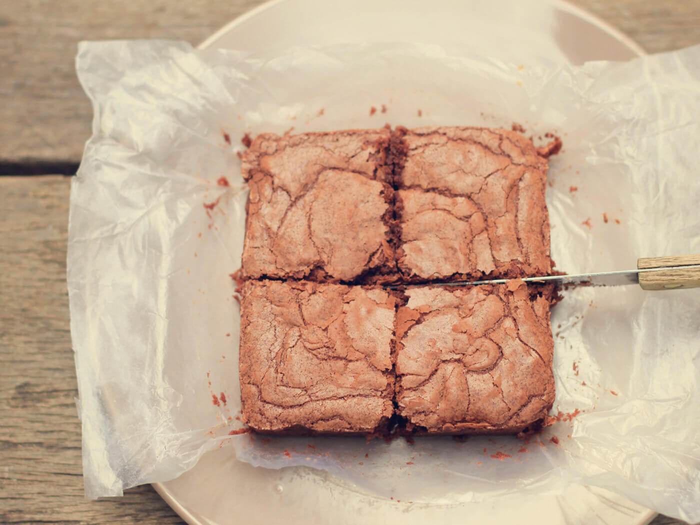 Cutting crispy homemade brownie with retro filter effect